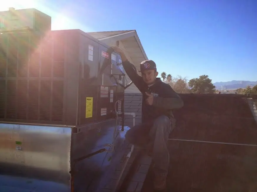 HVAC technician performing Air Duct Repair on a rooftop unit in Ross